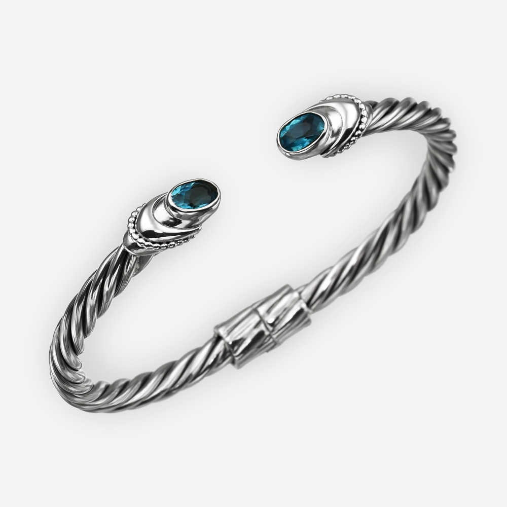 Pulsera de plata fina de cable torcido con zirconia cúbica azul.